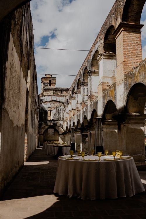 Free A beautifully arranged dining table set within the historic stone ruins, capturing a blend of elegance and antiquity. Stock Photo