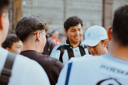 Free A group of young men gathers outdoors, casually engaging with a smartphone. Stock Photo