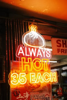 Vibrant neon sign promoting hot dumplings for 35 each. Perfect for street and food photography.