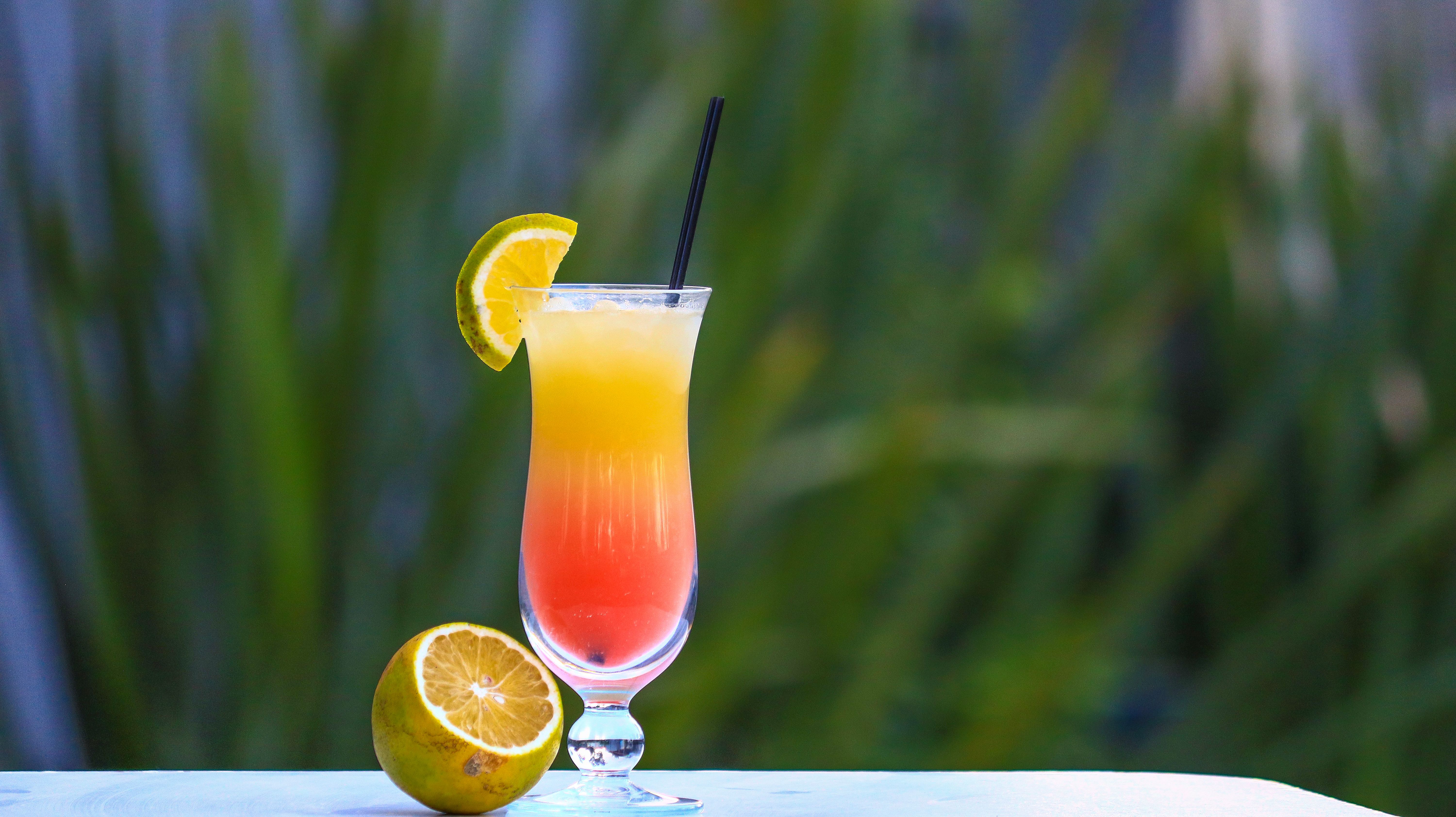 A glass pitcher of colorful non alcoholic summer drinks featured at the store