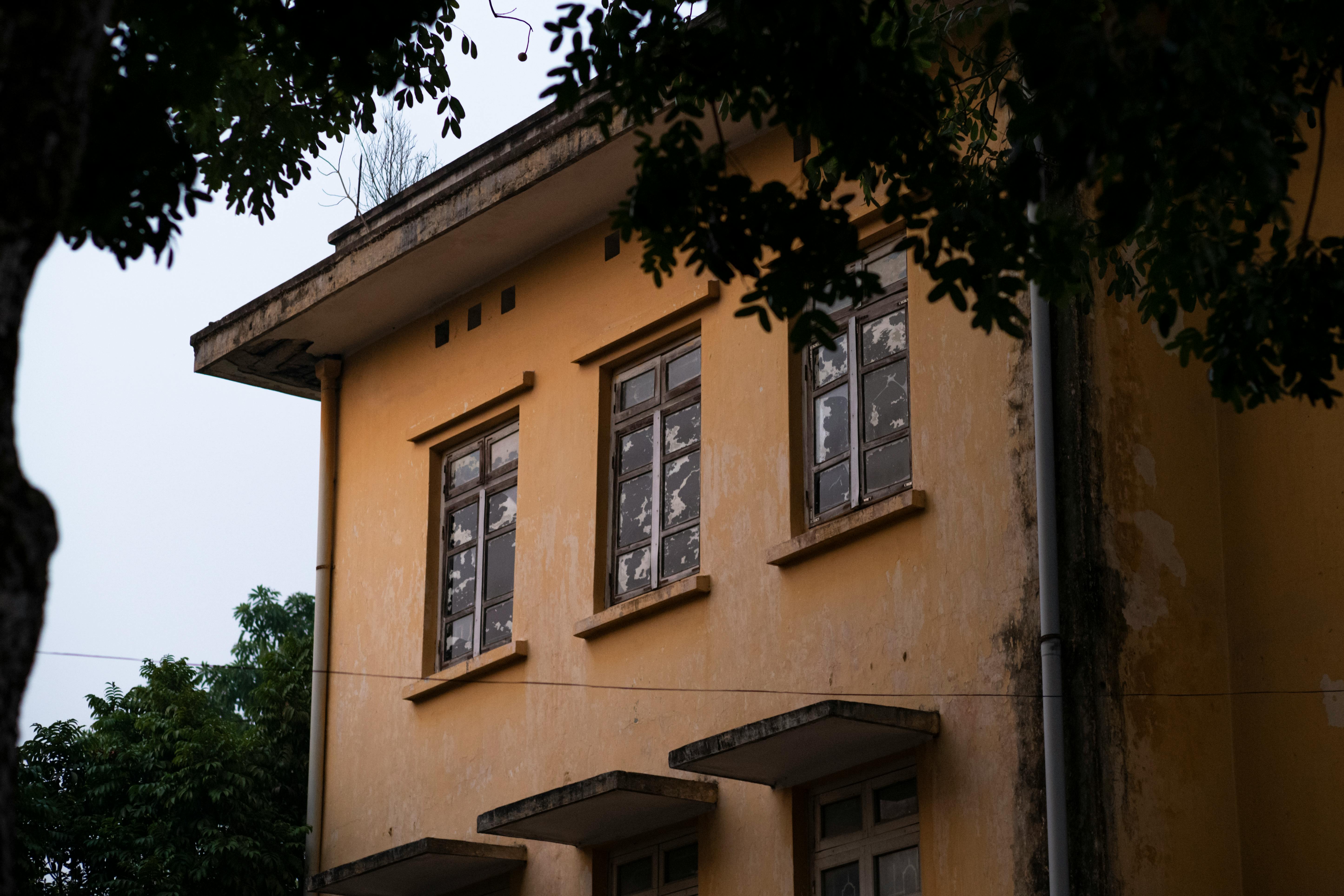 Gratis Un edificio amarillo antiguo capturado al aire libre en Hanoi, Vietnam, que muestra la arquitectura tradicional. Foto de stock
