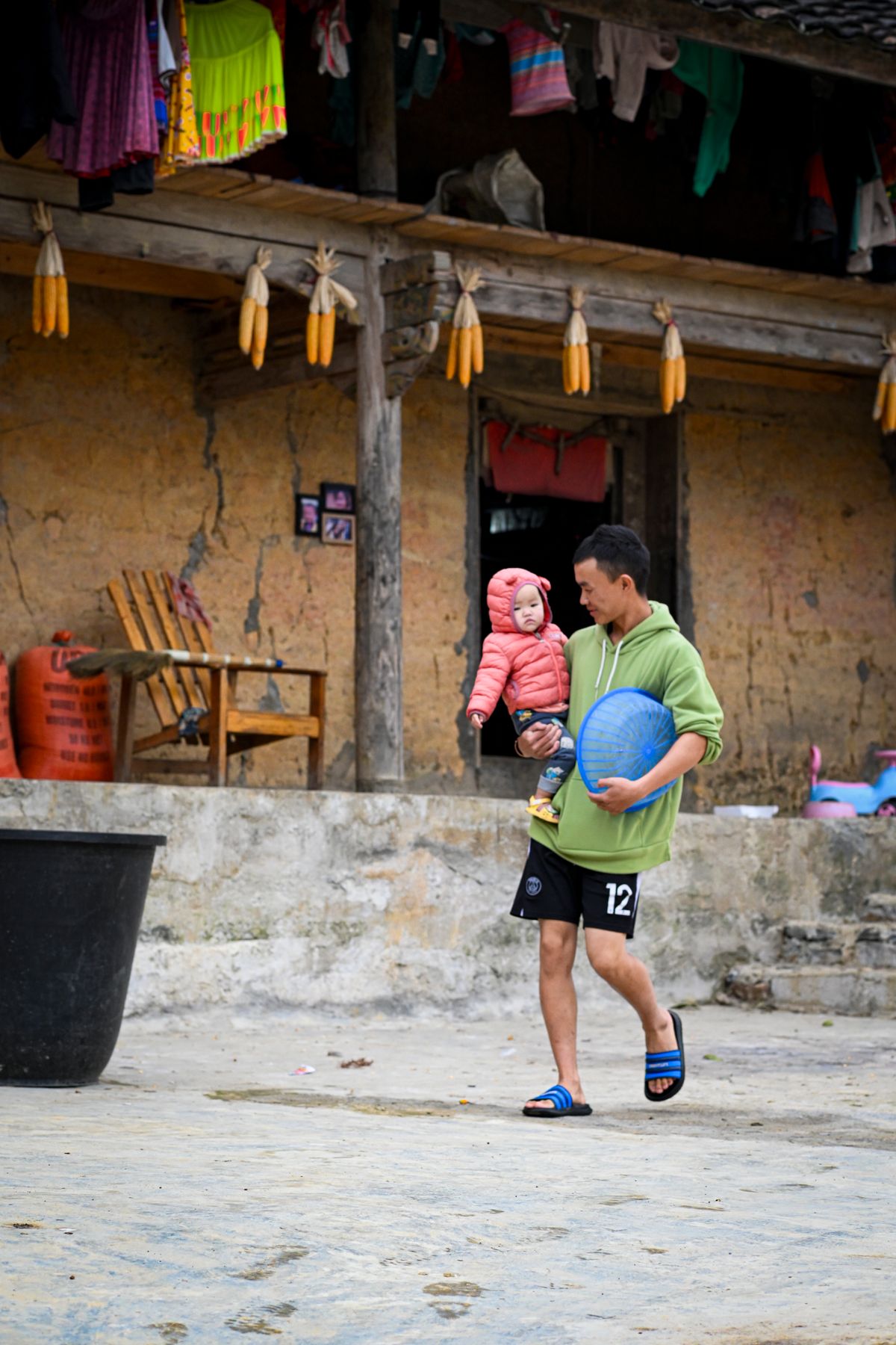 Local man carrying a child in a rural Ha Giang village