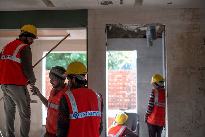Construction workers in safety gear at an indoor building site