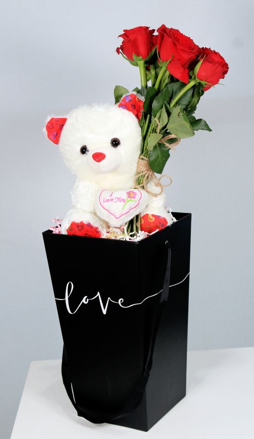 Free Elegant black bag with red roses and a cute teddy bear, perfect for Valentine's Day. Stock Photo