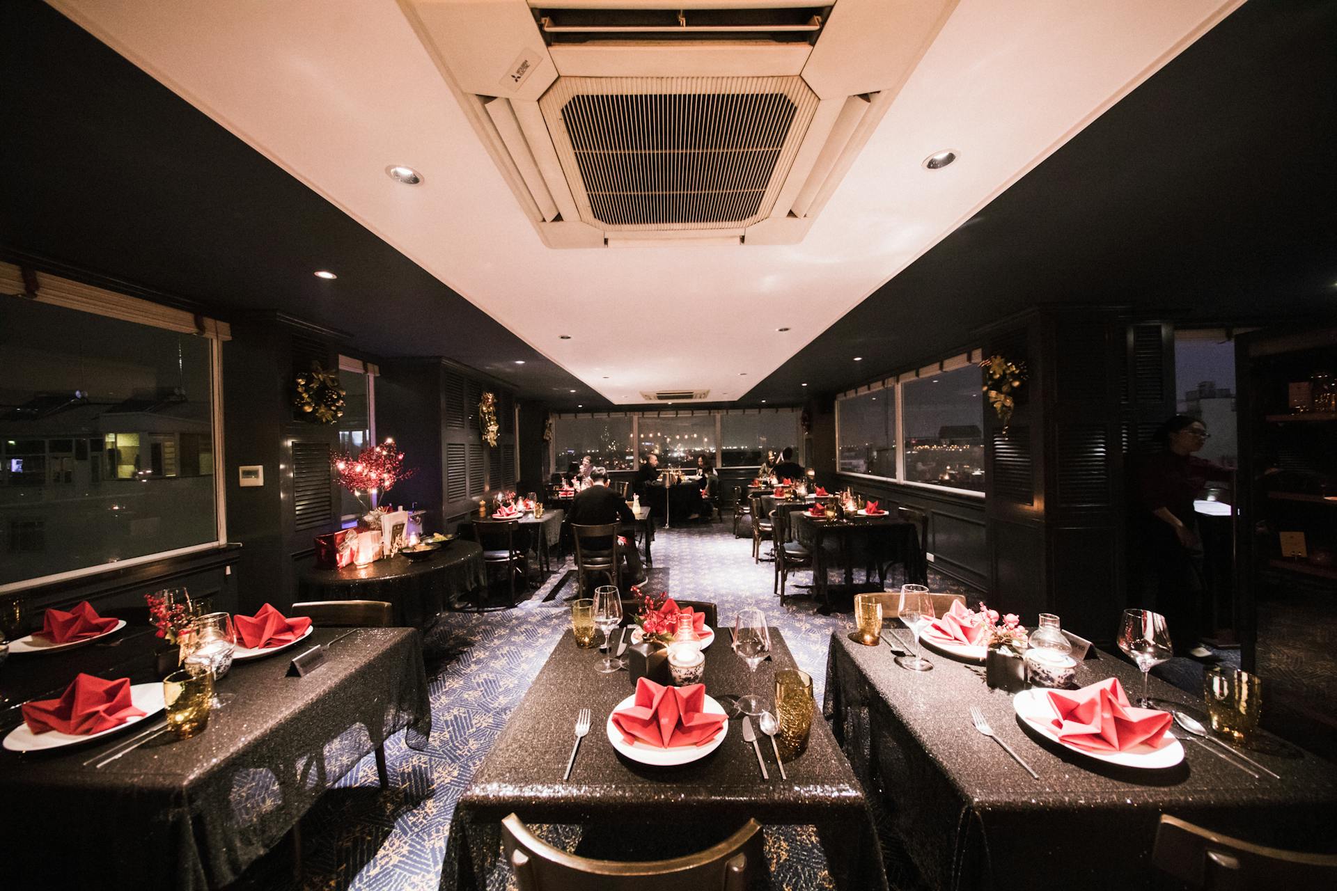 Spacious upscale dining area with festive decor, ready for an evening event.