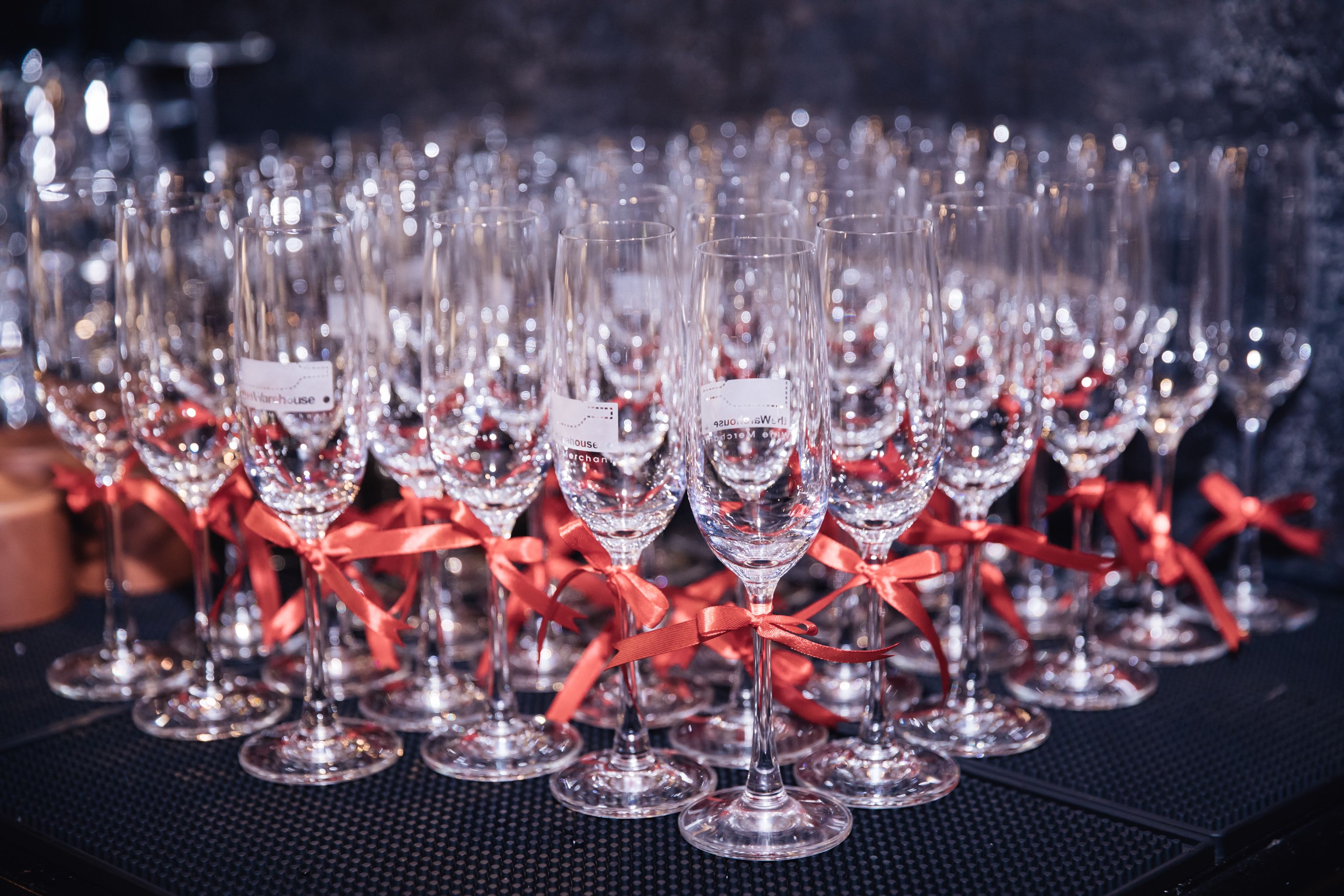 A collection of champagne glasses elegantly decorated with red ribbons, perfect for celebrations.