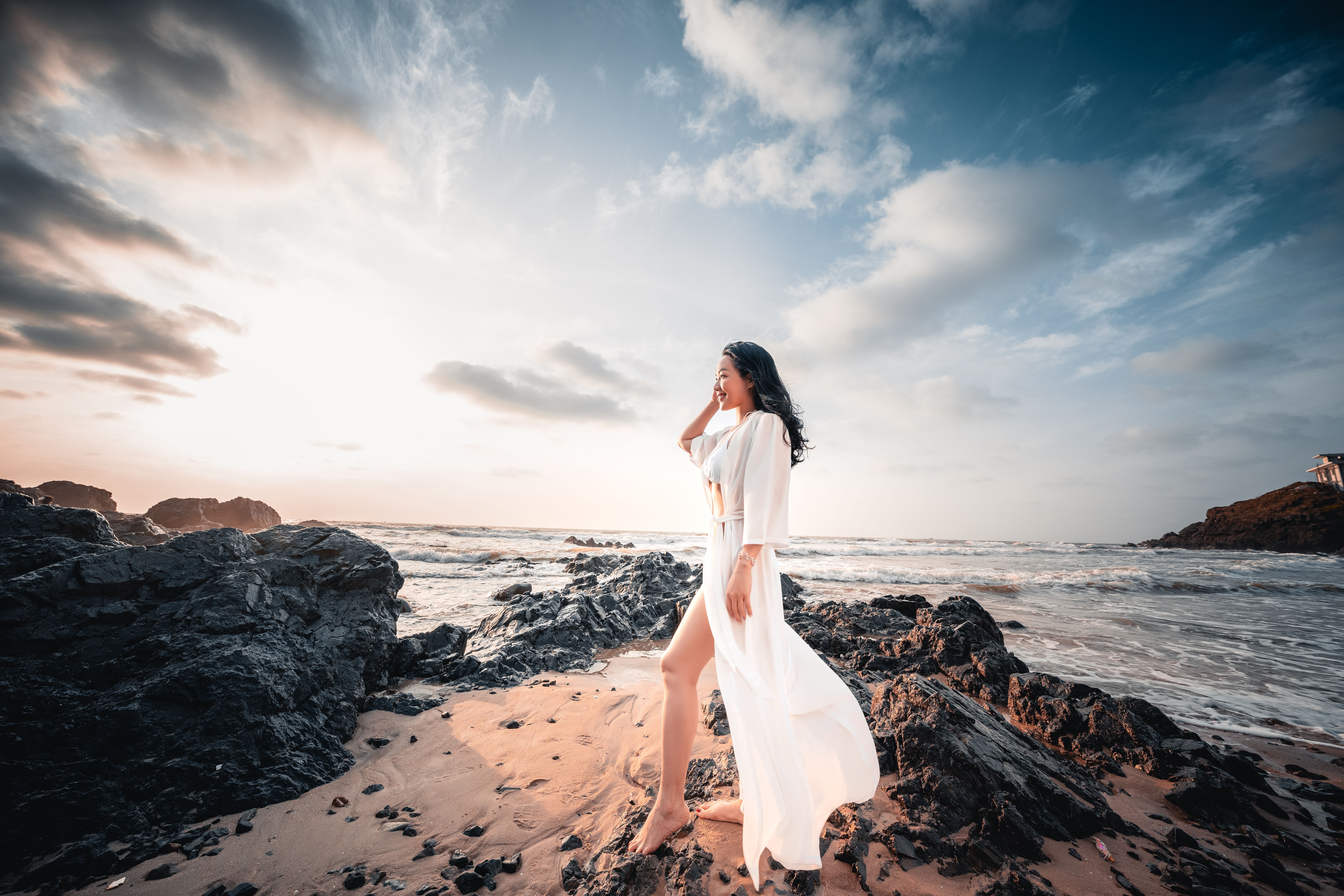Woman in White Dress Walking on Rocky Beach · Free Stock Photo