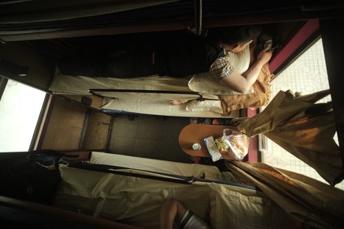 Cabina cuccetta di un treno notturno europeo con letti a castello e biancheria.