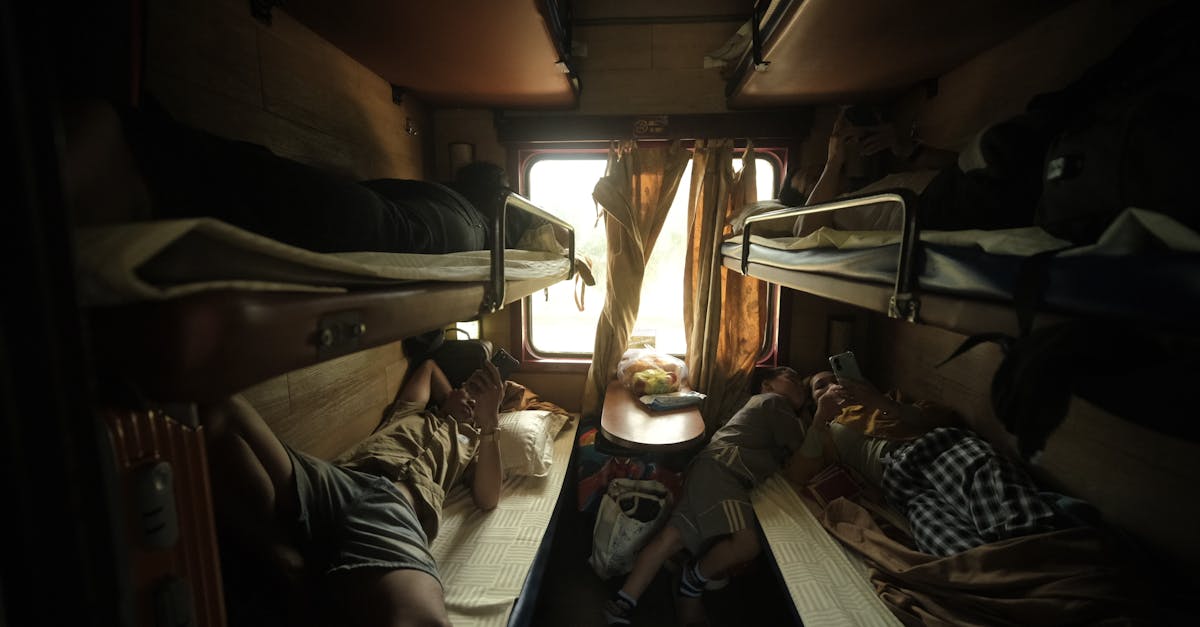 Passengers resting in a cozy train cabin with bunk beds and a window view.