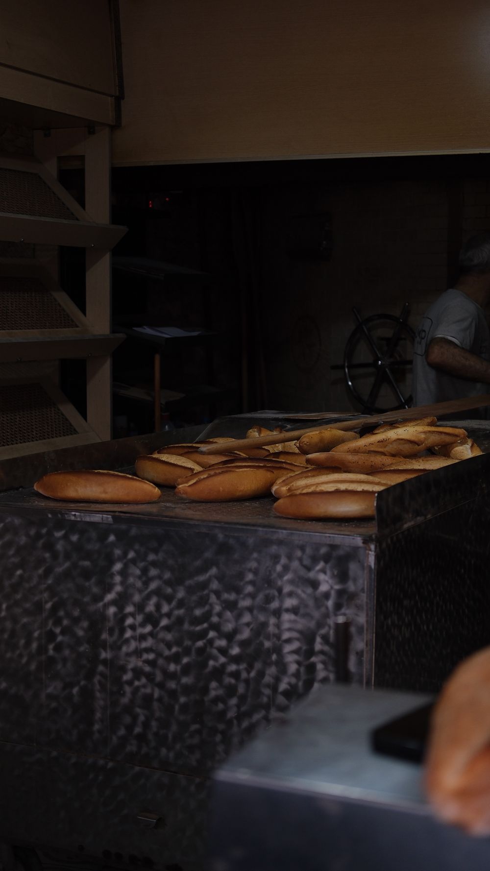 Barras recién horneadas sobre la salida del horno, en un obrador en penumbra