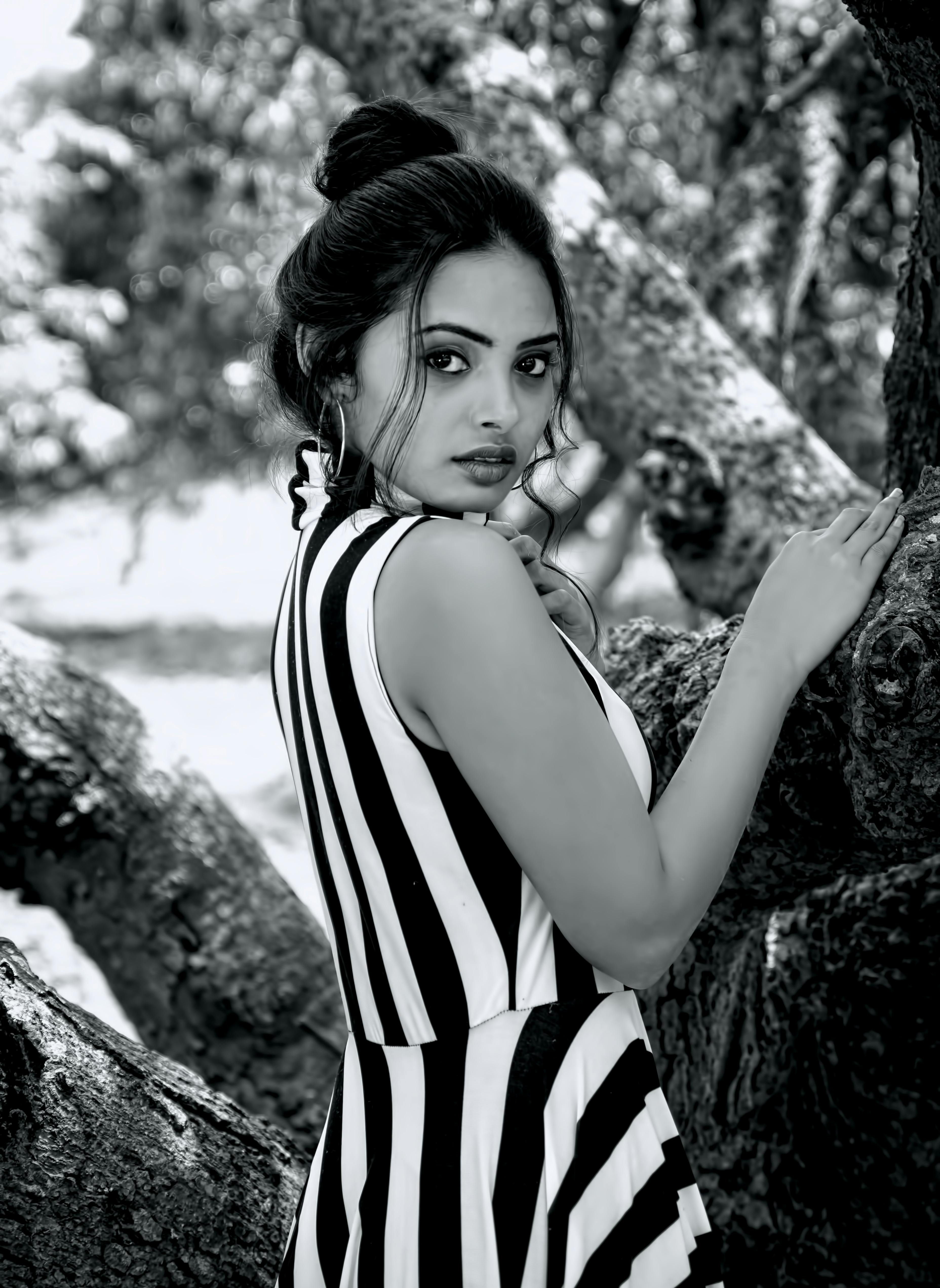 一位身着条纹连衣裙的女子，在户外背景下优雅地呈现黑白肖像
