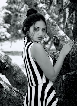 一位身着条纹连衣裙的女子，在户外背景下优雅地呈现黑白肖像