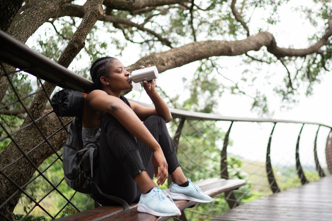 Photo Of Woman Leaning On Handrail having something to drink