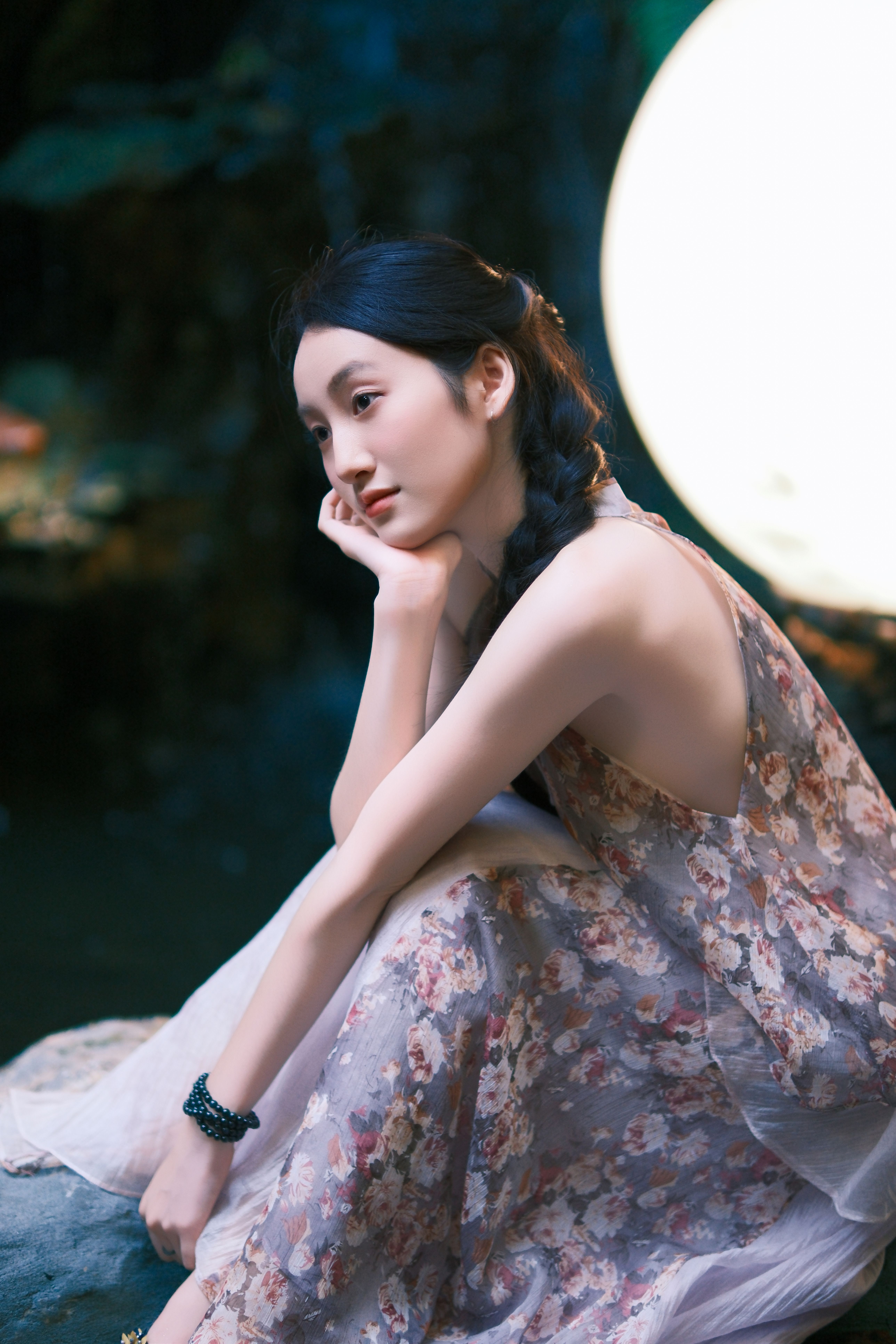 Thoughtful Woman in Floral Dress Next to Large Light · Free Stock Photo