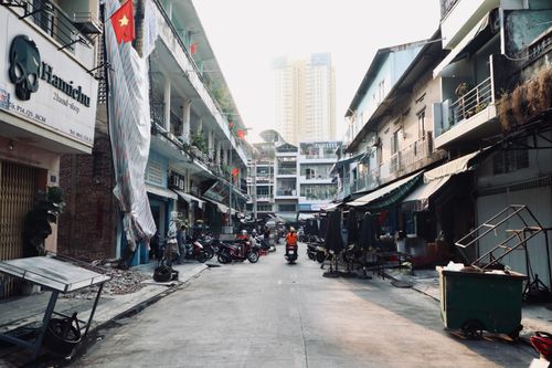 Free A vibrant street scene in a Vietnamese city with motorbikes and flags. Stock Photo