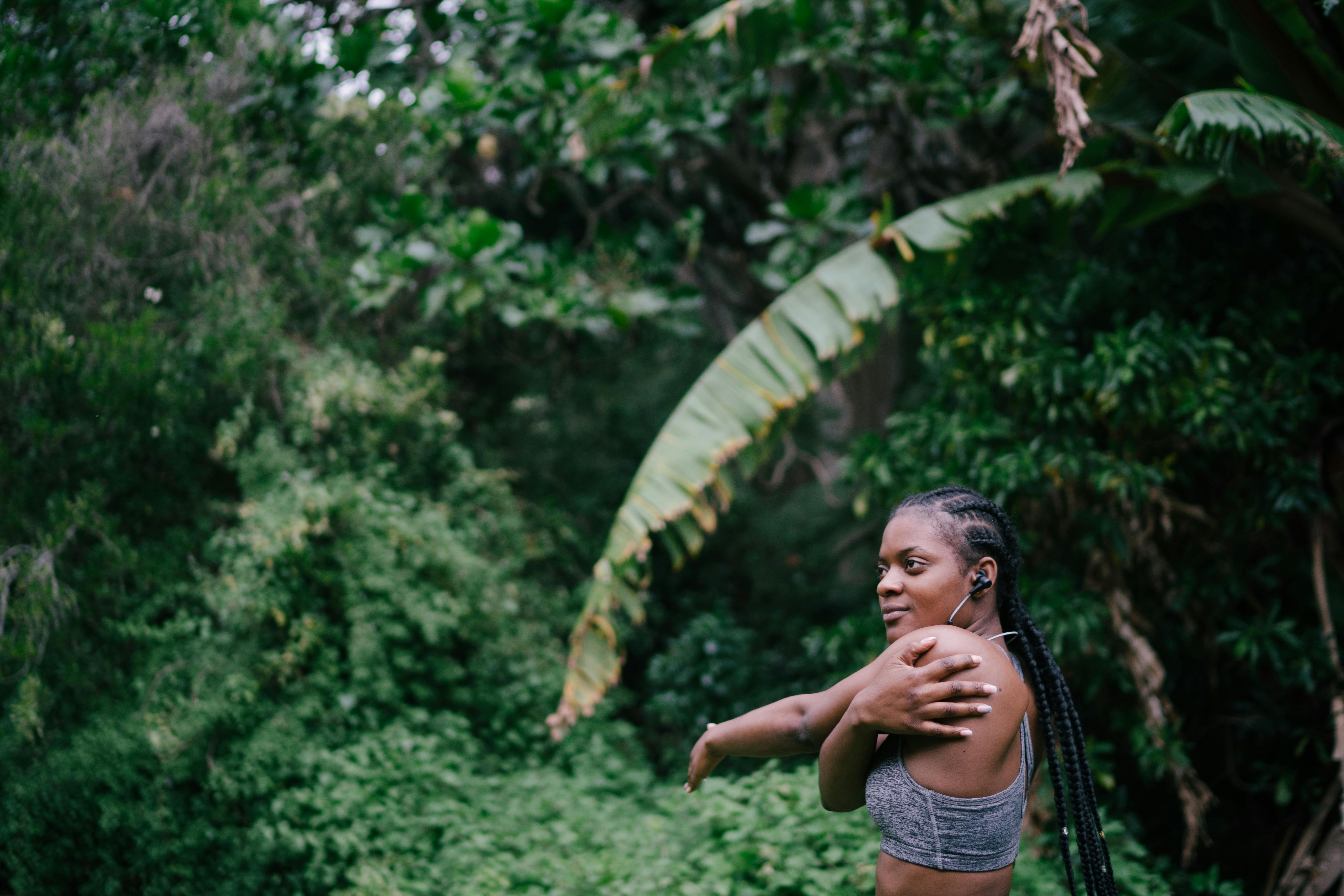 Photo Of Woman Stretching Near Plants
