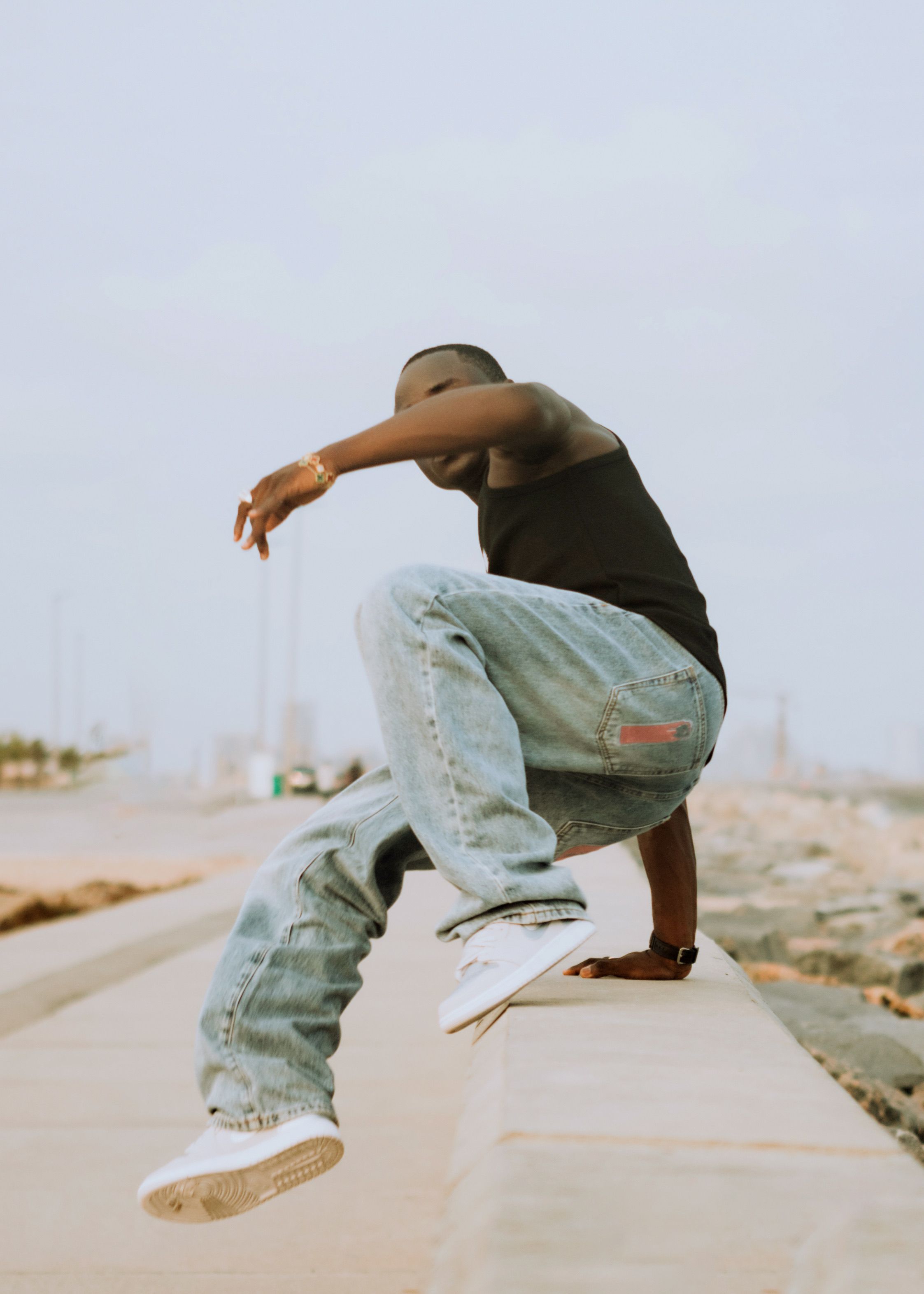 Dynamic photo of a skateboarder mid-trick on a city street during the day.