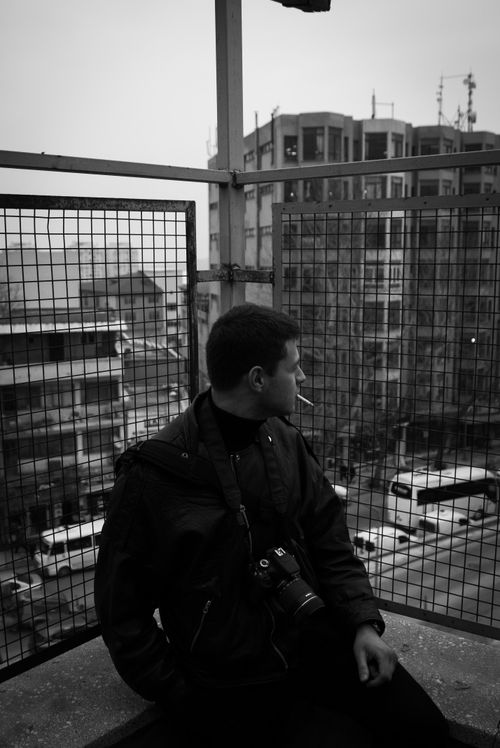 Free Black and white image of a person with camera overlooking urban cityscape. Stock Photo