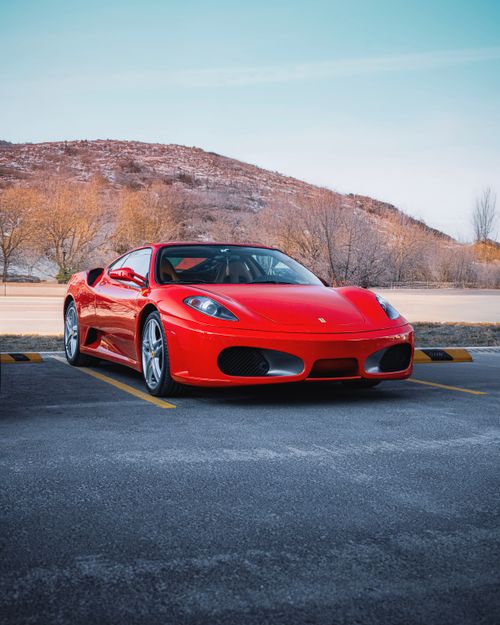 Free A stunning red Ferrari car parked against a scenic Ankara backdrop, showcasing luxury and style. Stock Photo