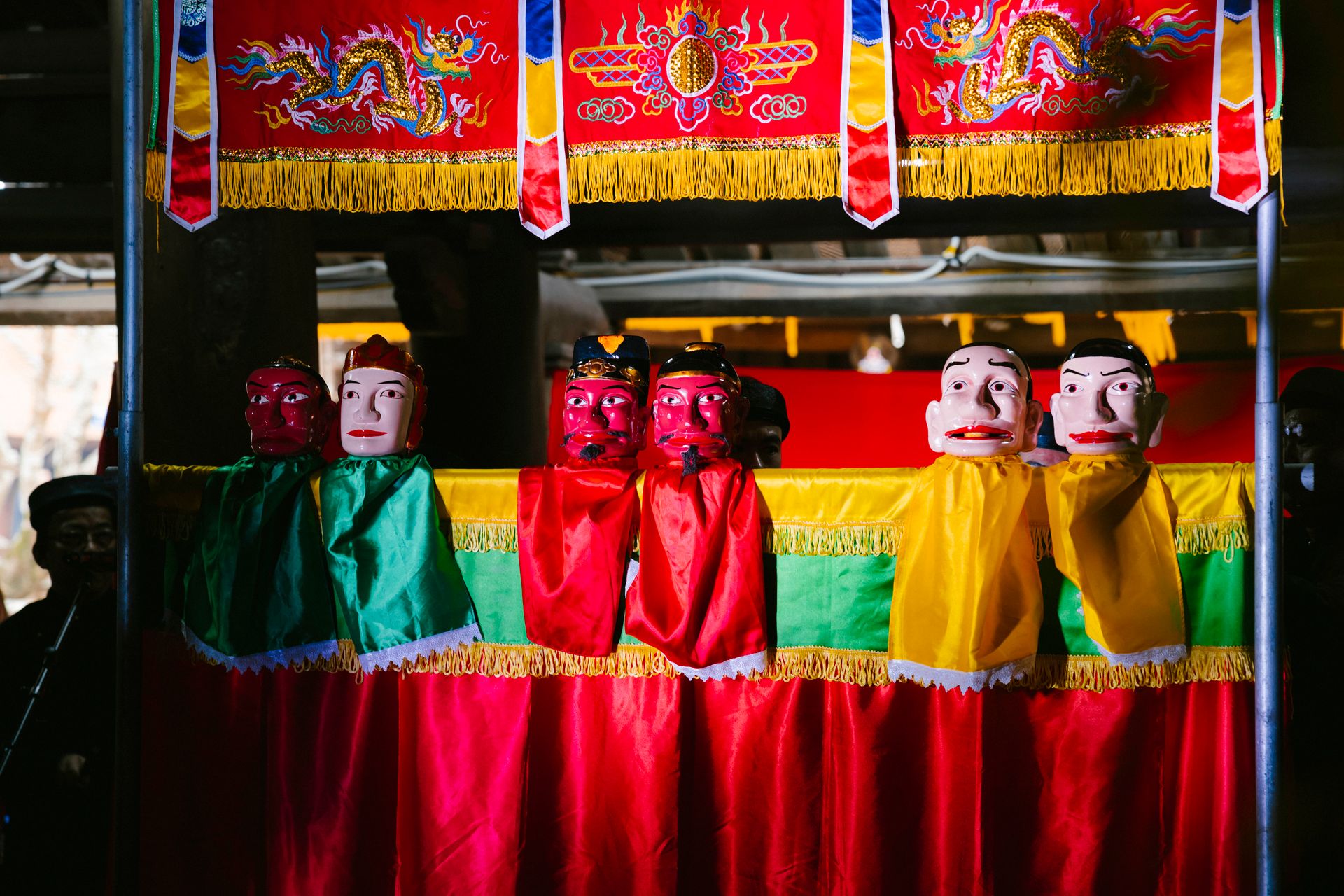 Colorful puppet show featuring traditional masks and costumes in a cultural setting.