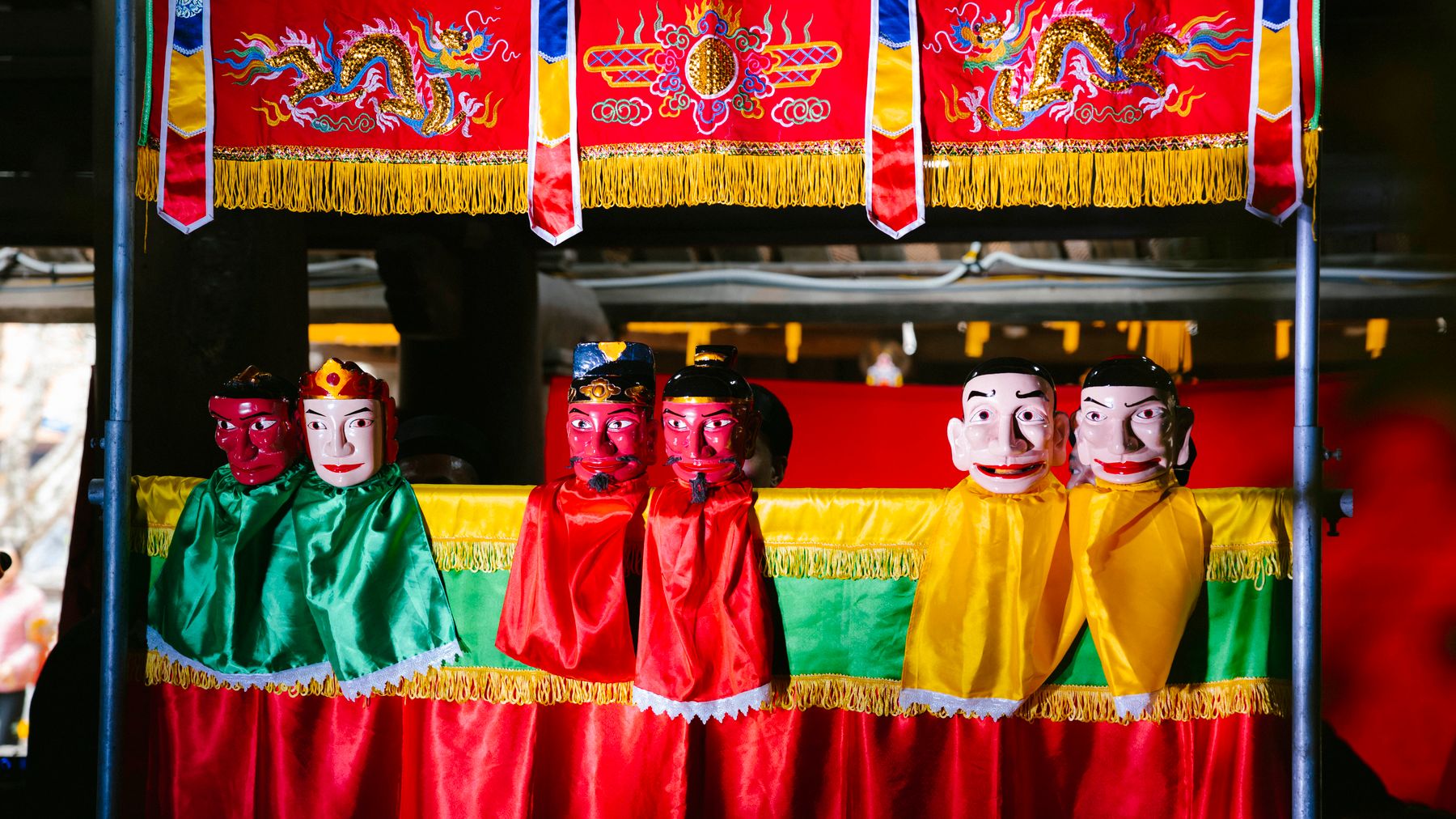 Colorful traditional puppet theater with vivid red, green, and yellow costumes.