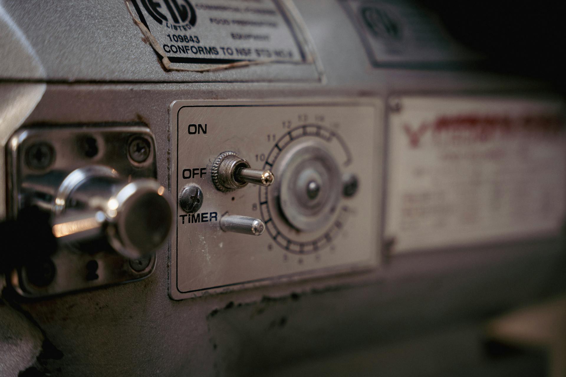 Detailed close-up of a vintage industrial machine control panel with knobs and switches.