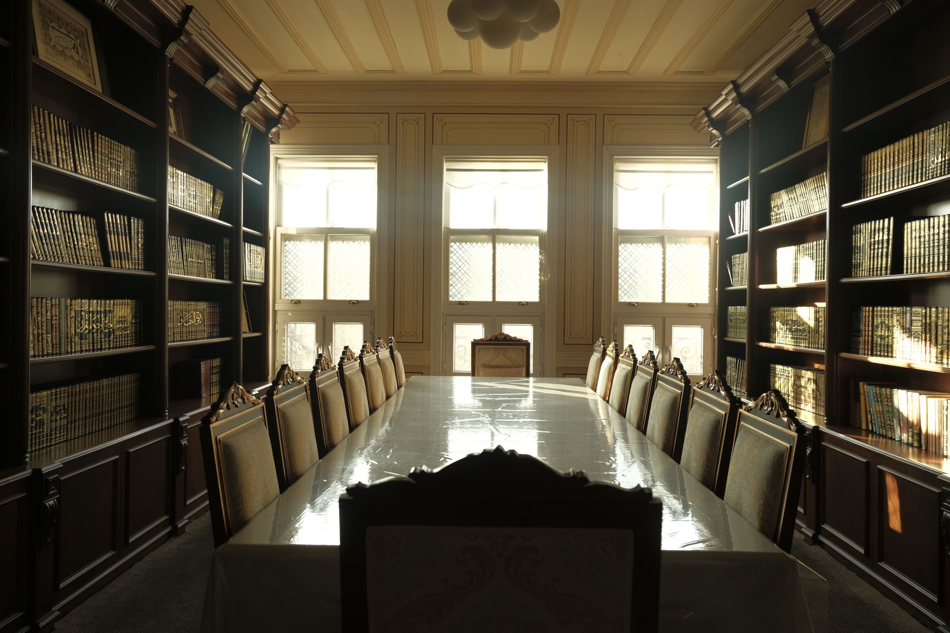Peaceful reading room in İstanbul with elegant chairs and bookshelves. Sunlit and tranquil.