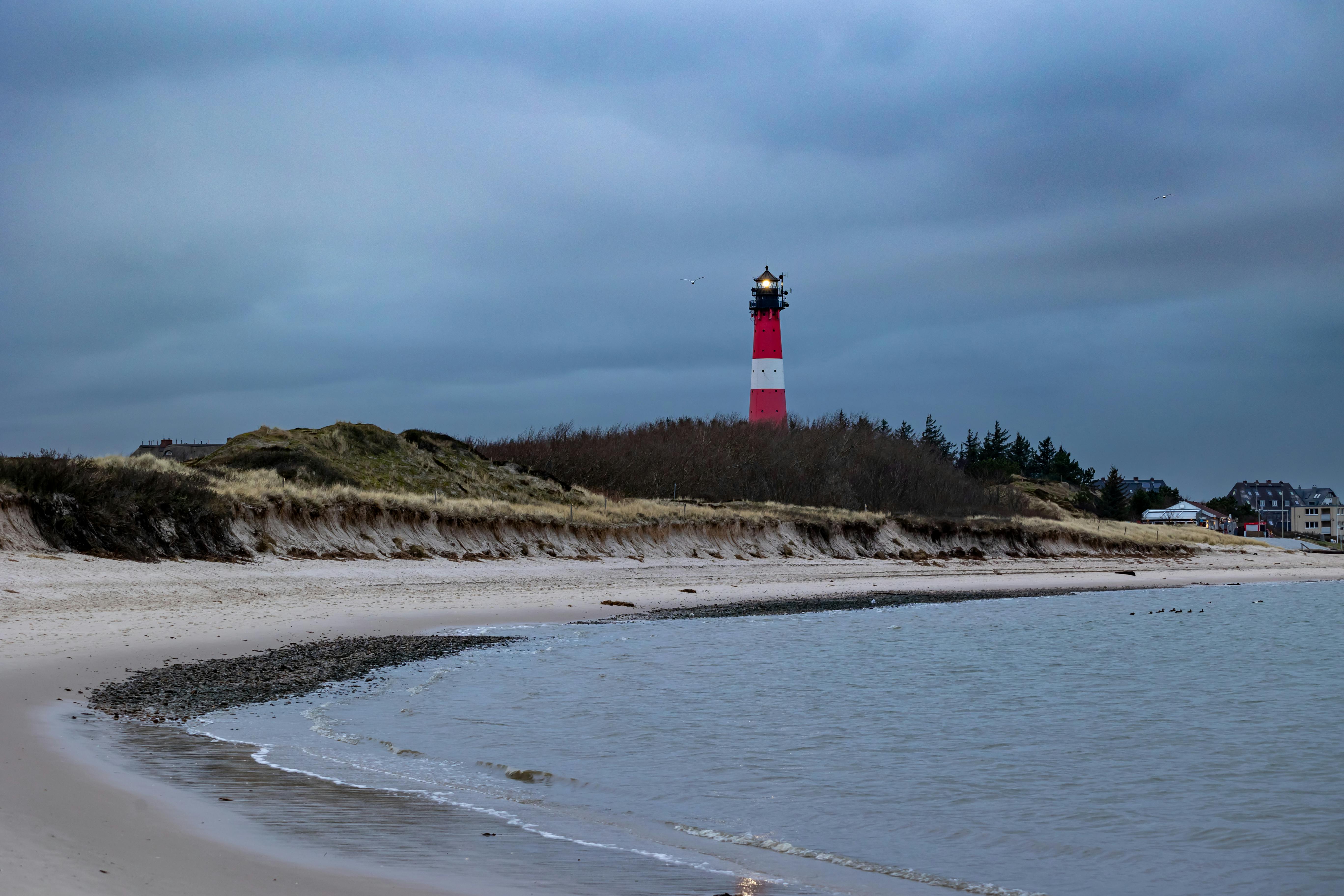 Gratuit Découvrez l'emblématique phare de Hörnum qui se dresse contre le rivage tranquille de la côte de Sylt. Photos