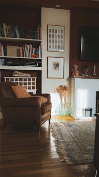 A warm and inviting living room featuring a leather chair and bookshelves bathed in soft sunlight.