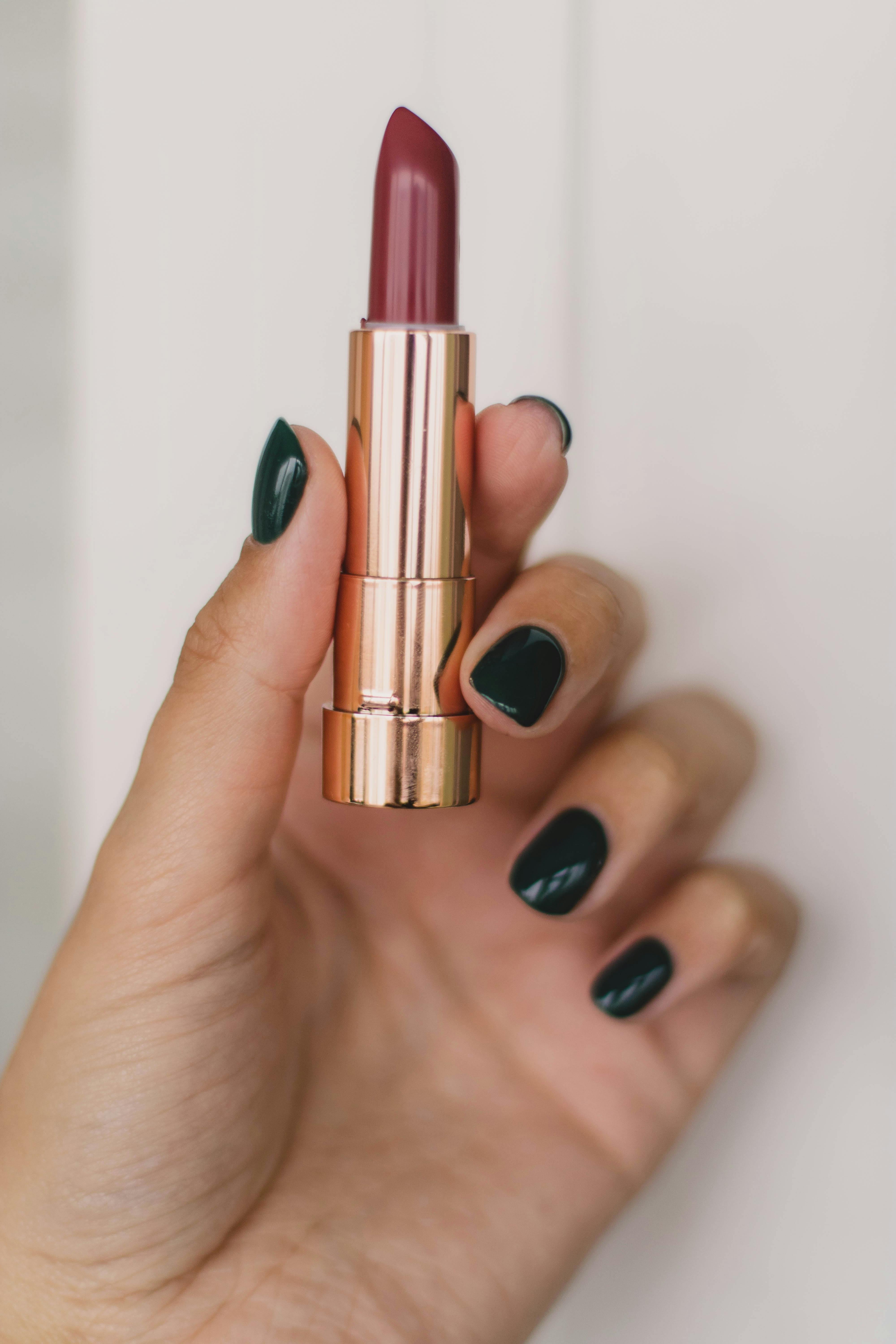 close up photo of person holding lipstick