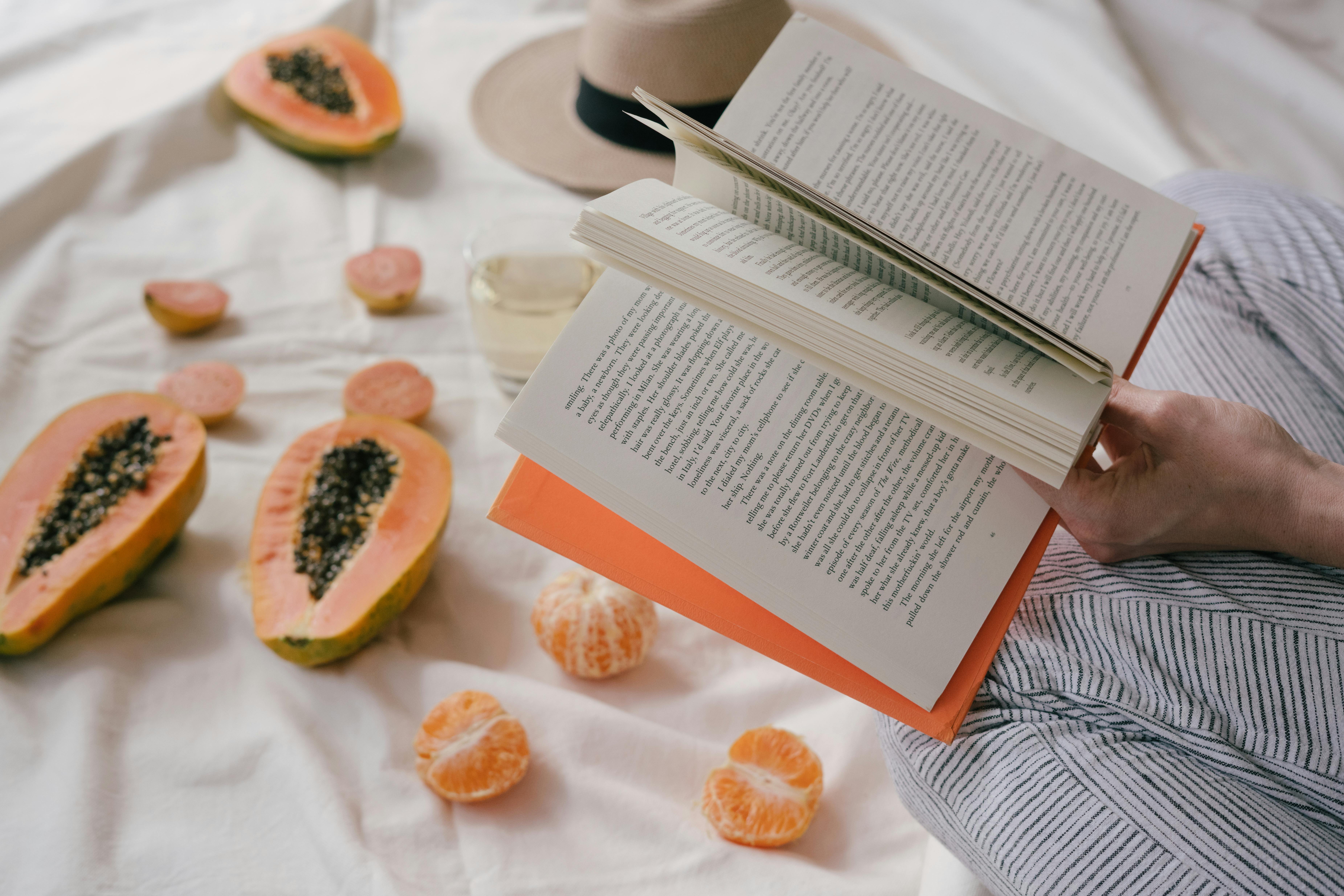 Opened Book And Sliced Papaya Fruit