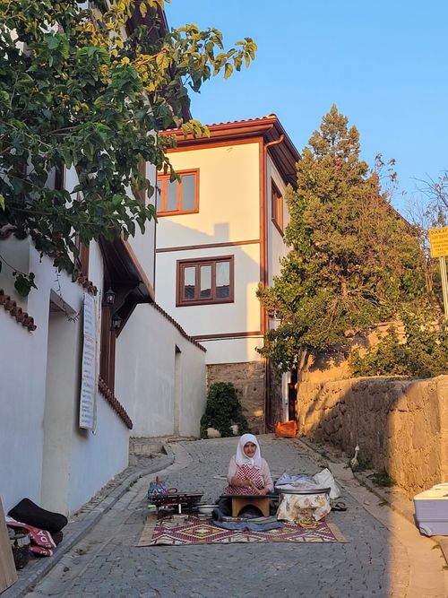 Free Woman selling traditional items in a scenic Ankara street. Captured in authentic setting. Stock Photo