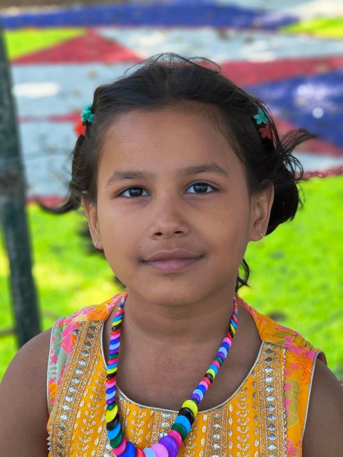 Free A close-up portrait of a young girl wearing vibrant traditional clothing and jewelry in an outdoor setting. Stock Photo