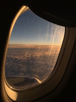 Breathtaking view of clouds from an airplane window at sunrise, capturing the serene beauty of the sky.