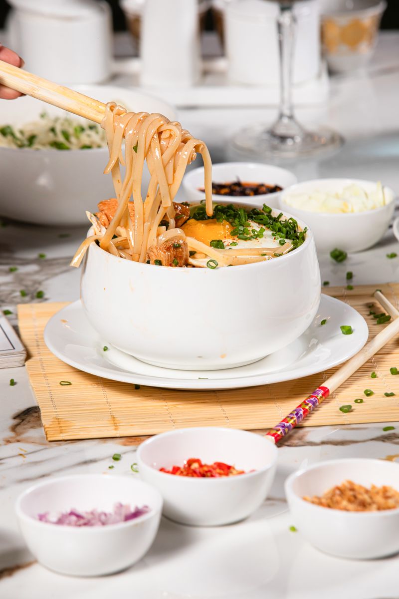 Delicious Asian noodles served in a bowl with chopsticks, vibrant garnishes.