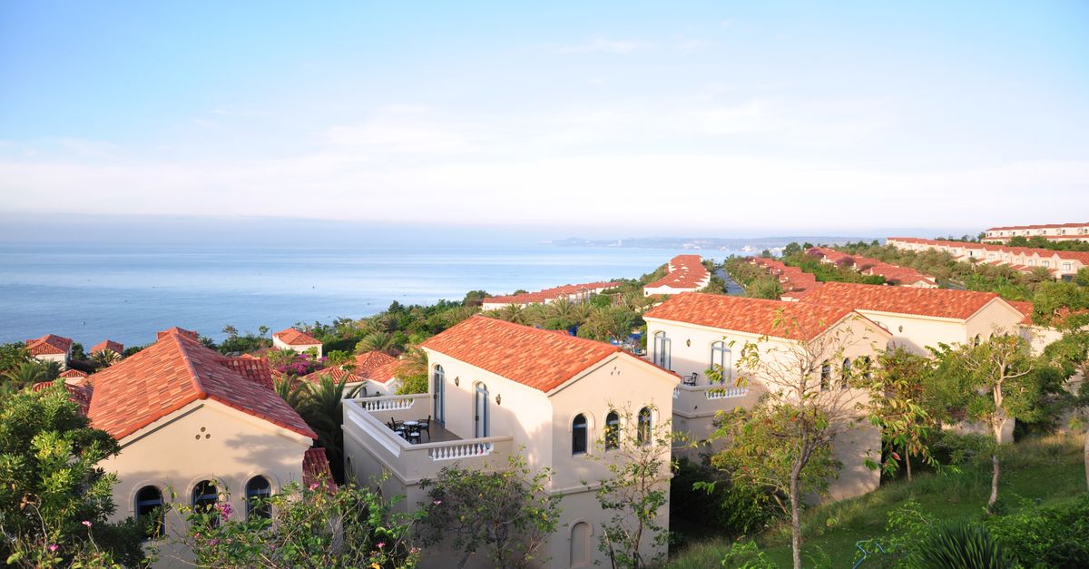 Beautiful Mediterranean villas overlooking a tranquil sea under clear skies.
