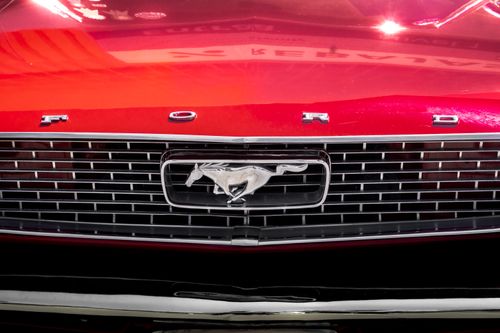 Free Detailed close-up of the iconic grille of a vintage red Ford Mustang. Stock Photo