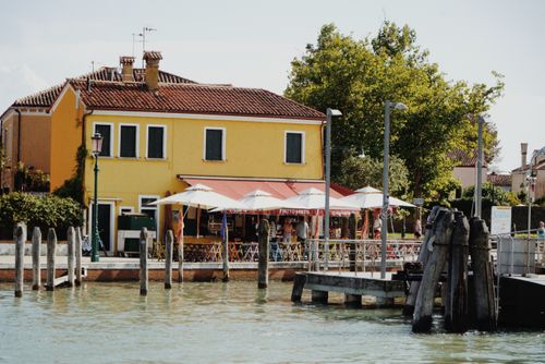 Free Colorful waterfront building with cafe in Burano, Venice, Italy under summer sun. Stock Photo
