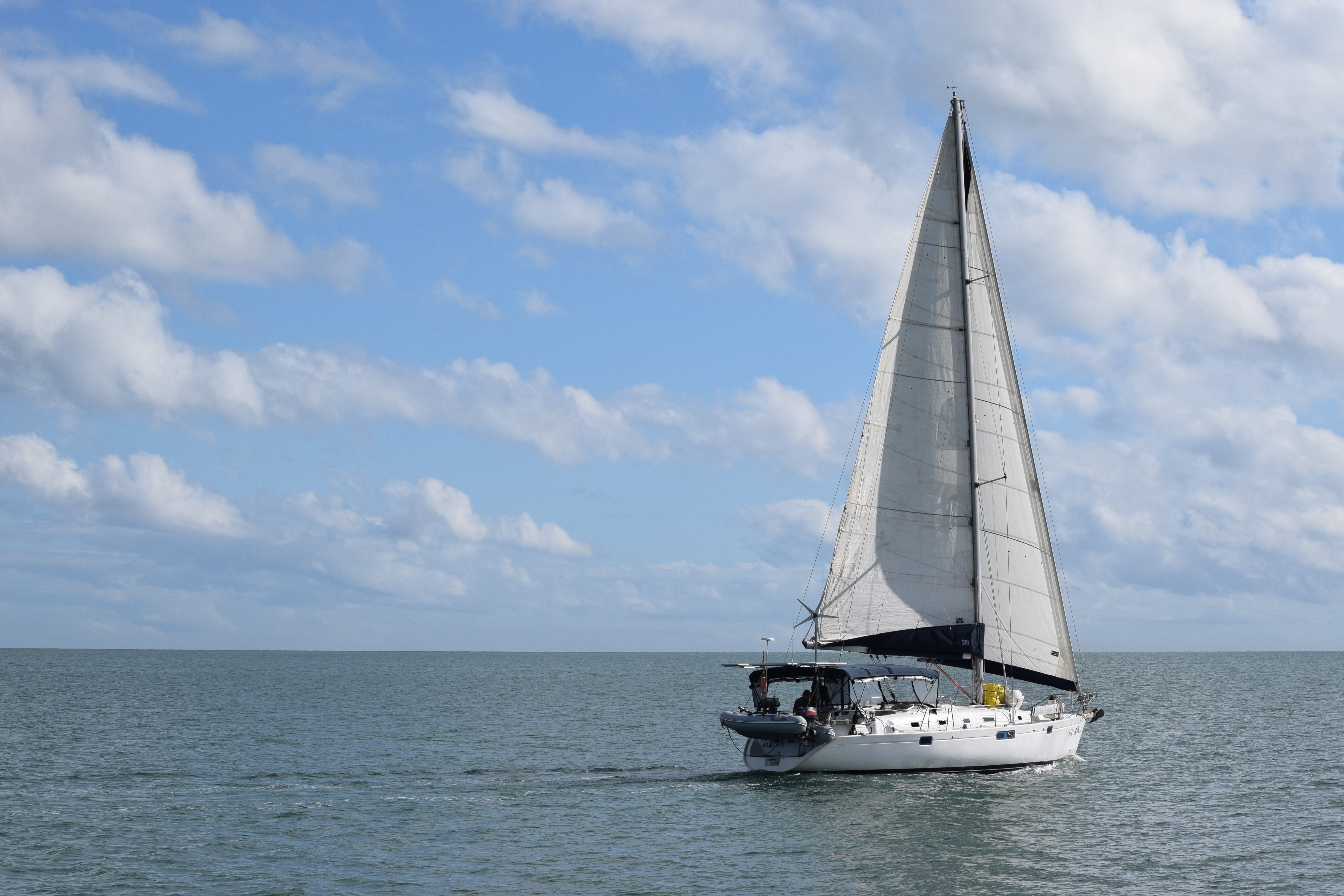 Sailing yacht with white sails on blue sea