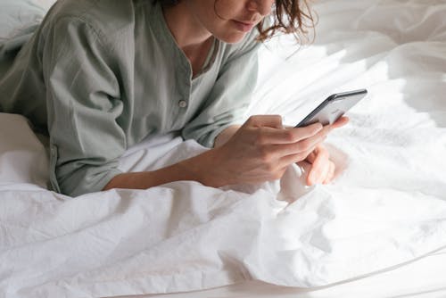 Woman Using Smartphone in Bed