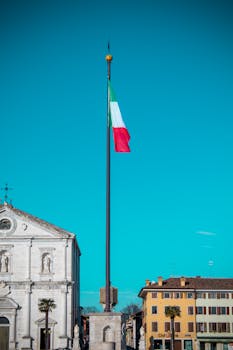 View of the Italian flag waving in central Palmanova's historic piazza in Italy.