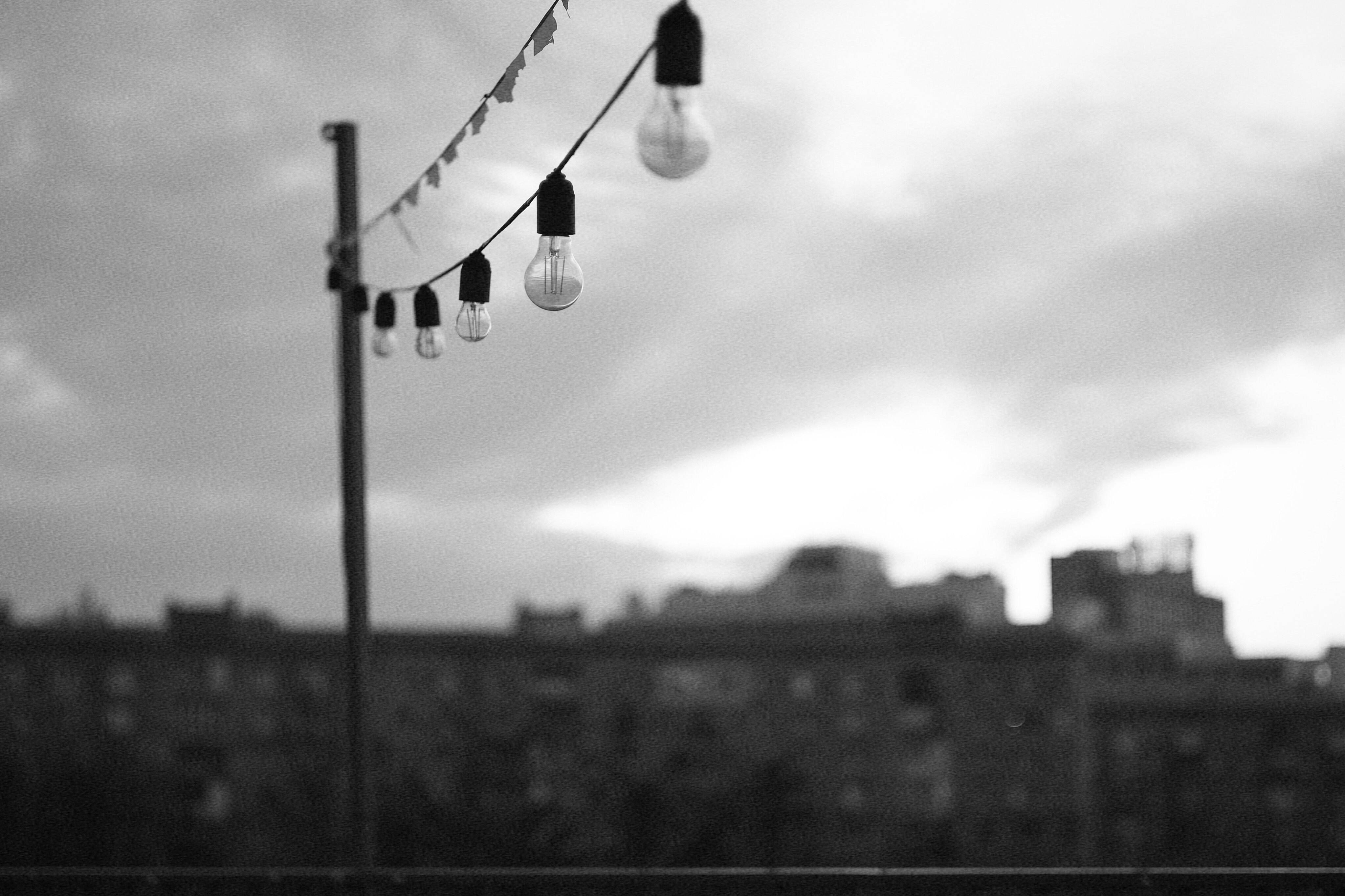 Black and White Cityscape with Hanging Bulbs · Free Stock Photo