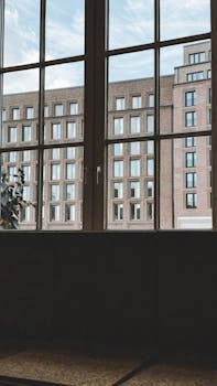 A daylight view of urban architecture framed by a large window, featuring multiple buildings.