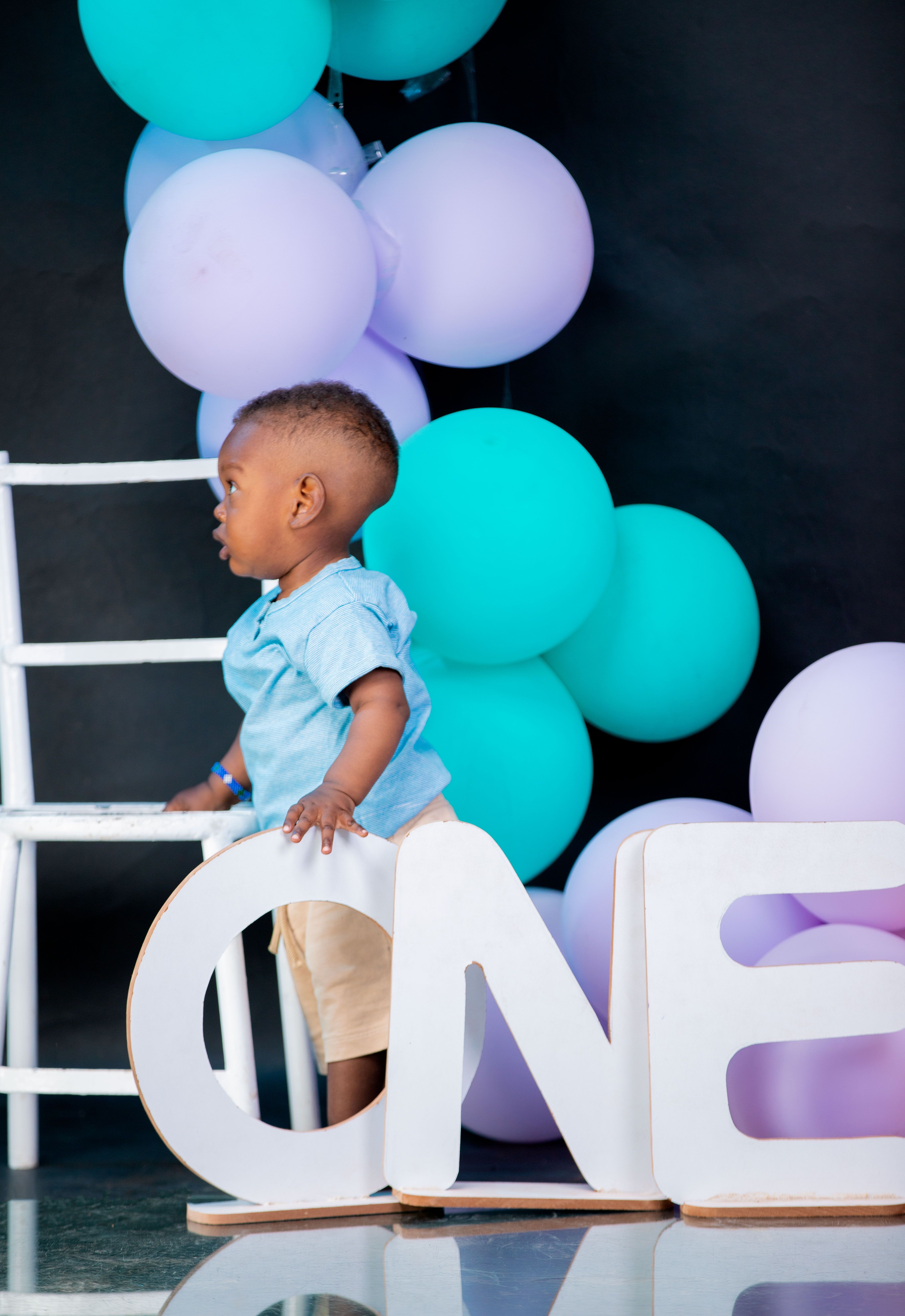 First birthday balloon decor ideas with child's first birthday with balloons and a One sign display