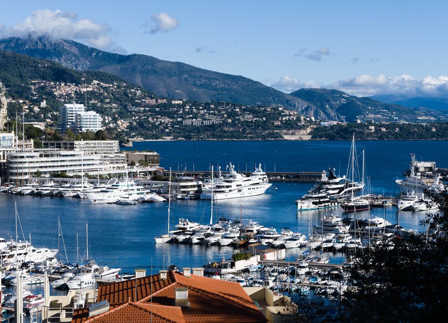 Breathtaking view of Monaco marina with luxurious yachts and scenic backdrop.