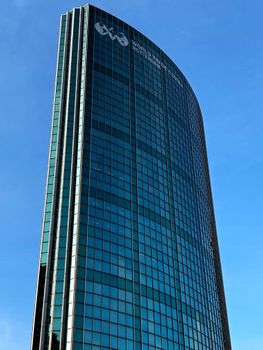 The modern World Trade Center skyscraper in Rotterdam, South Holland, under a clear blue sky.