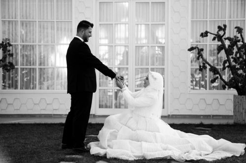 Free Elegant black and white photo of bride and groom outdoors in a classic pose. Stock Photo