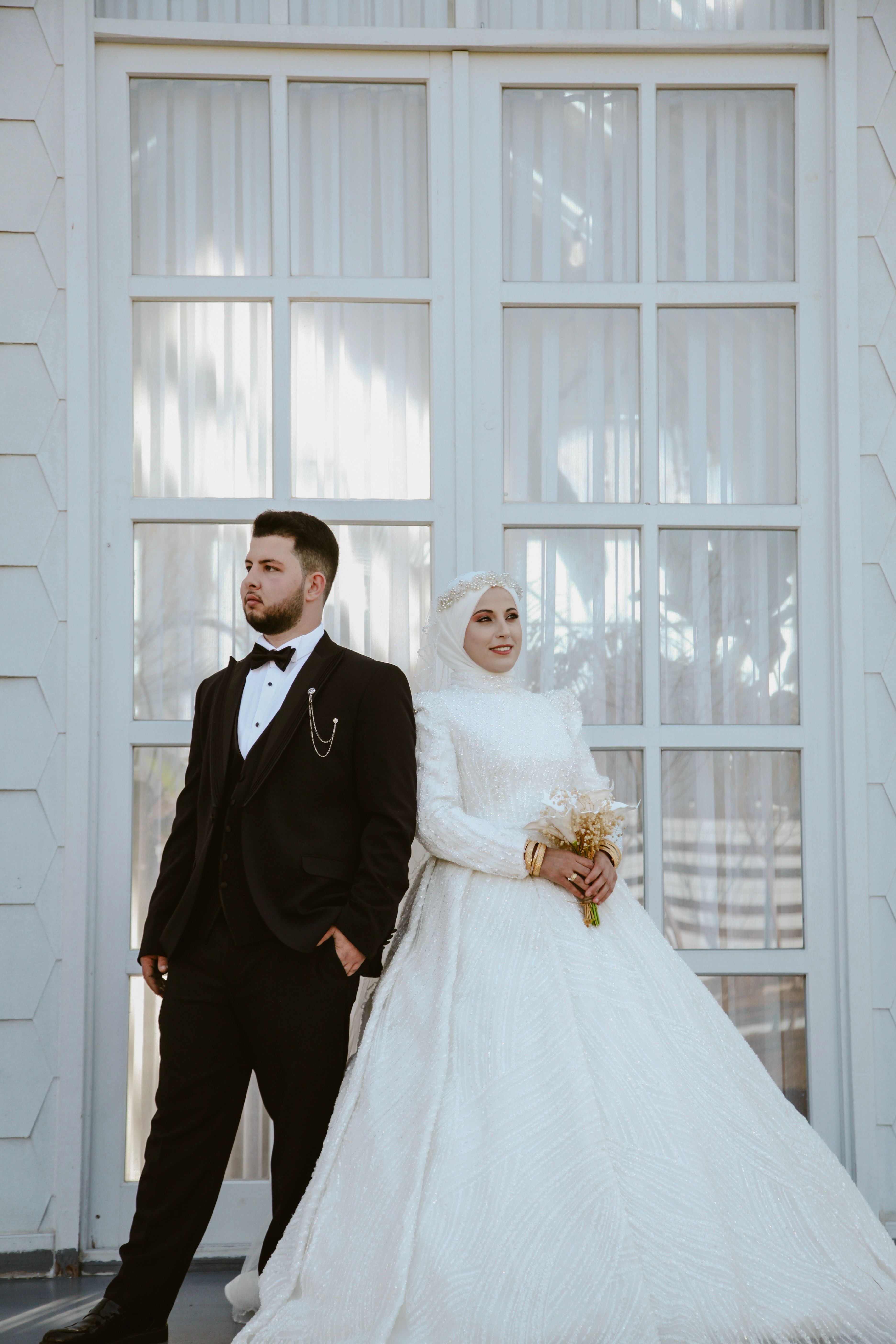 Muslim bride in hijab and groom in formal wedding attire