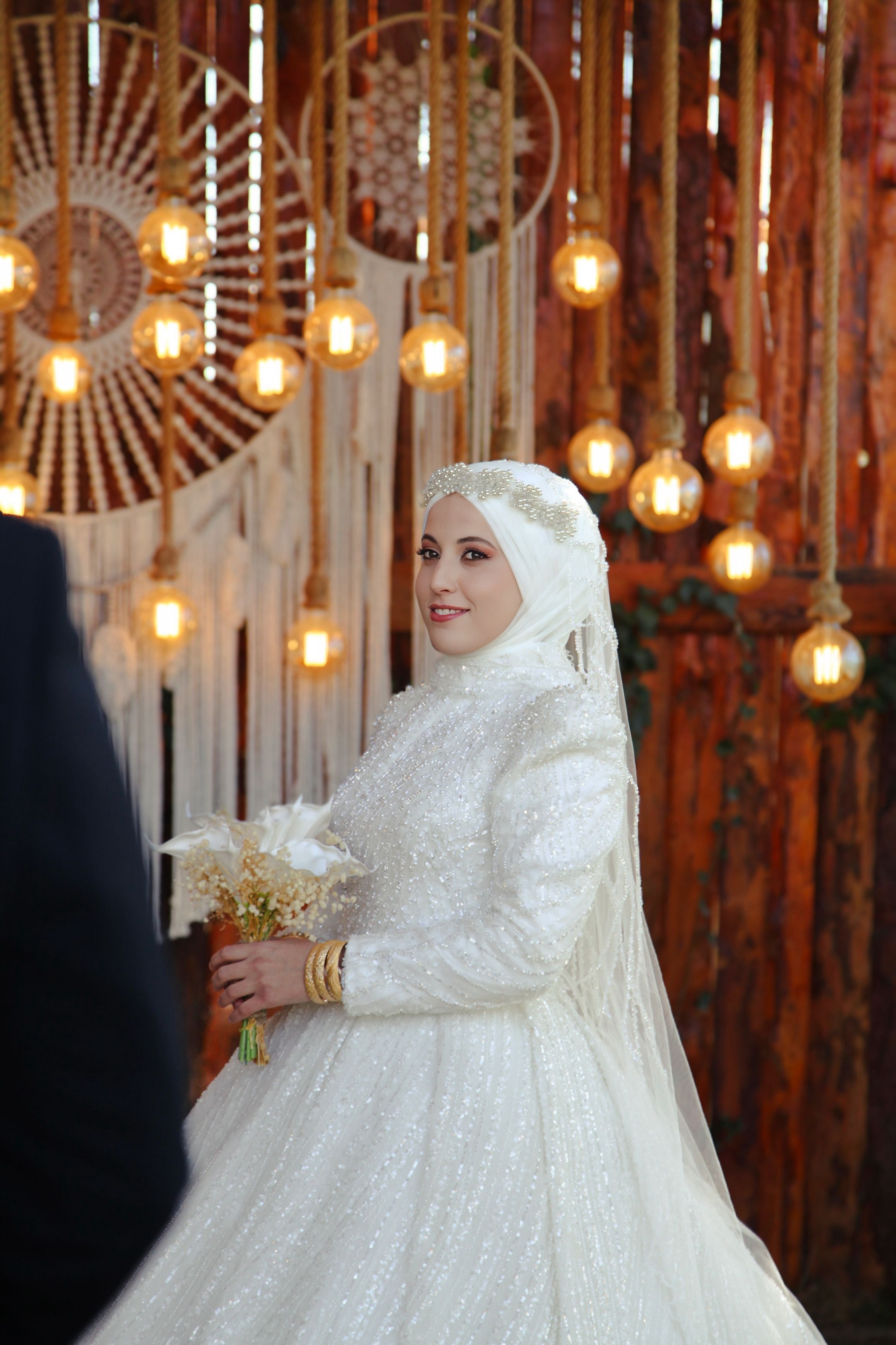 Bridal portrait with warm rustic lighting and elegant attire, capturing a wedding moment.