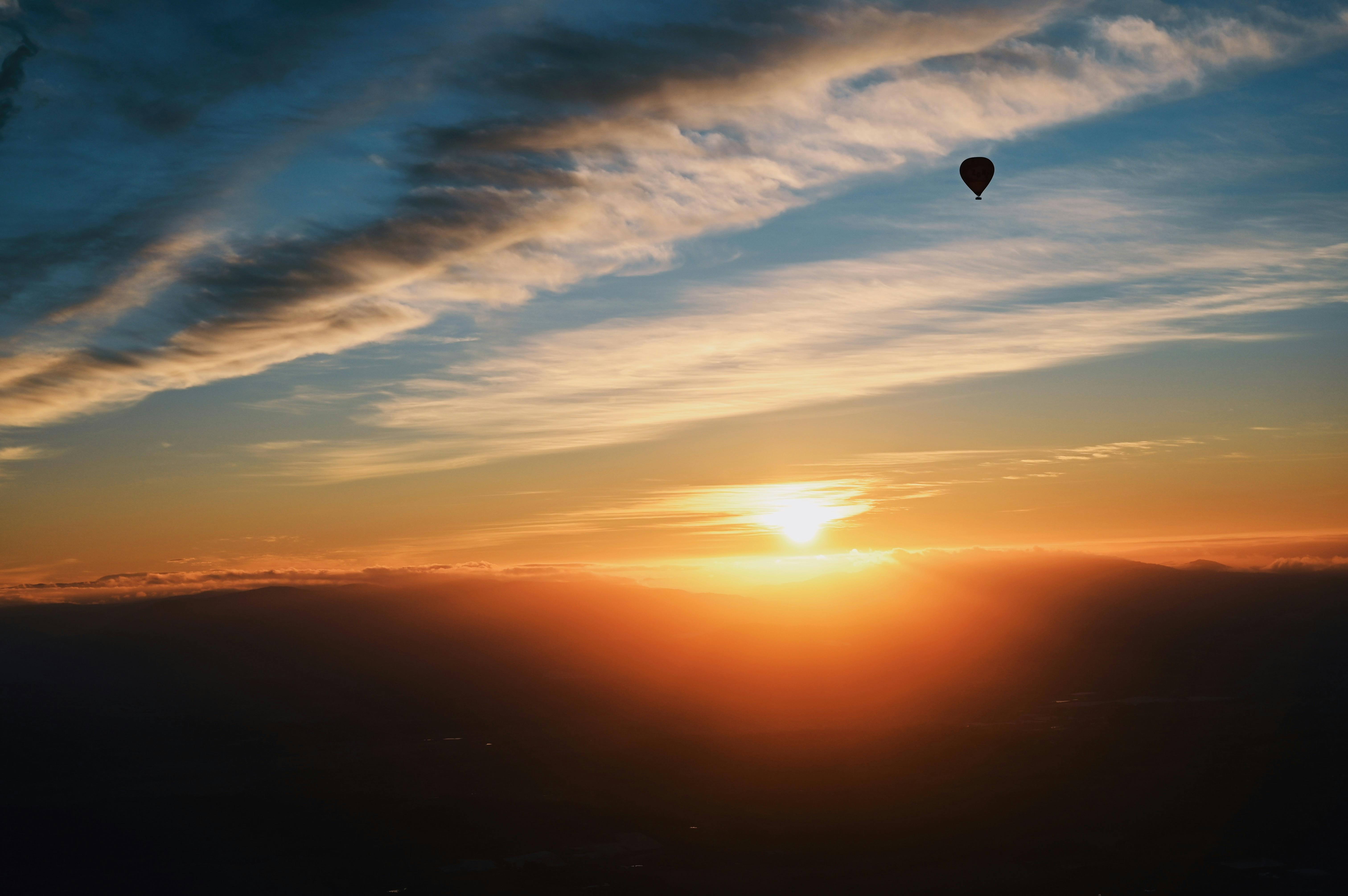 Gün doğumunda gökyüzünde uçan büyük bir sıcak hava balonu